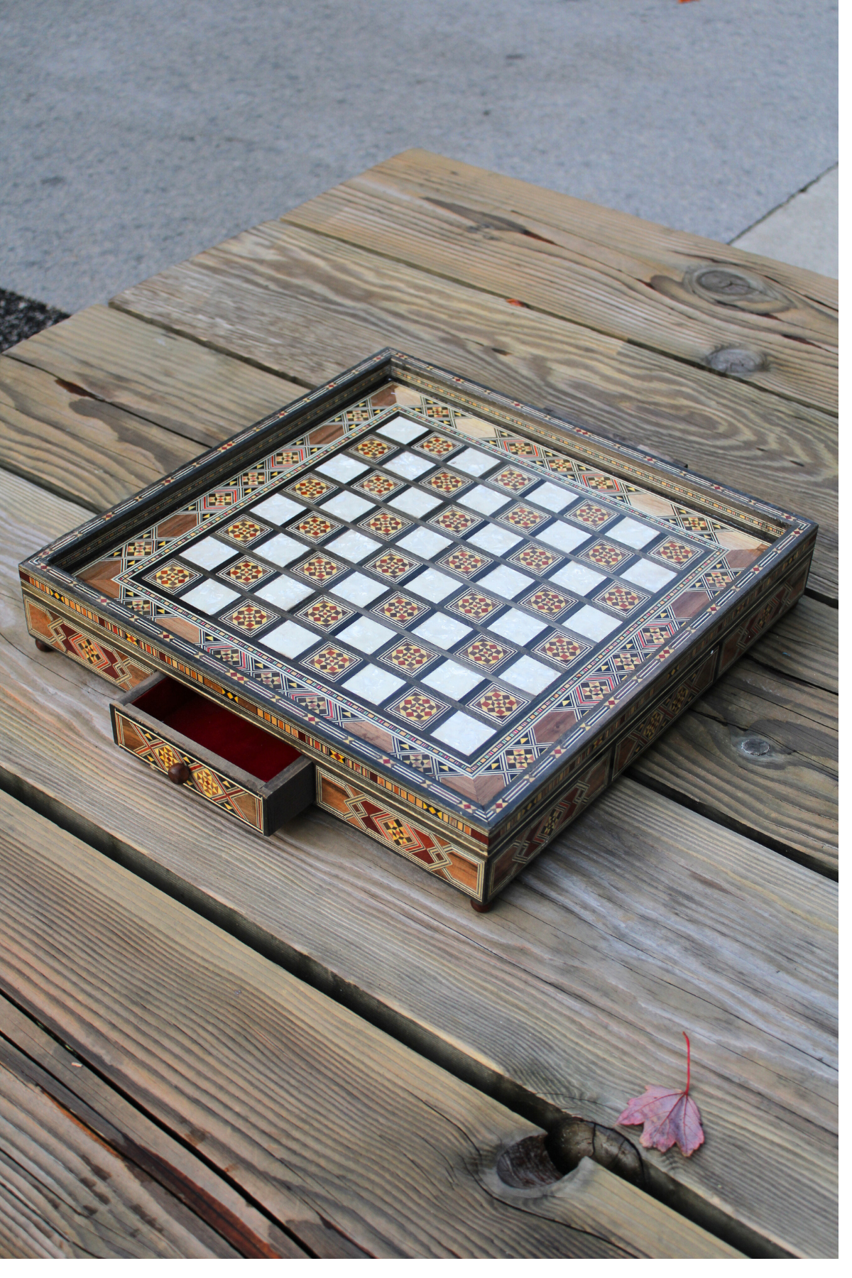 Wider view of the chess board with the drawer open, capturing the elegant design and craftsmanship while highlighting the spacious storage area, all without any chess pieces present.