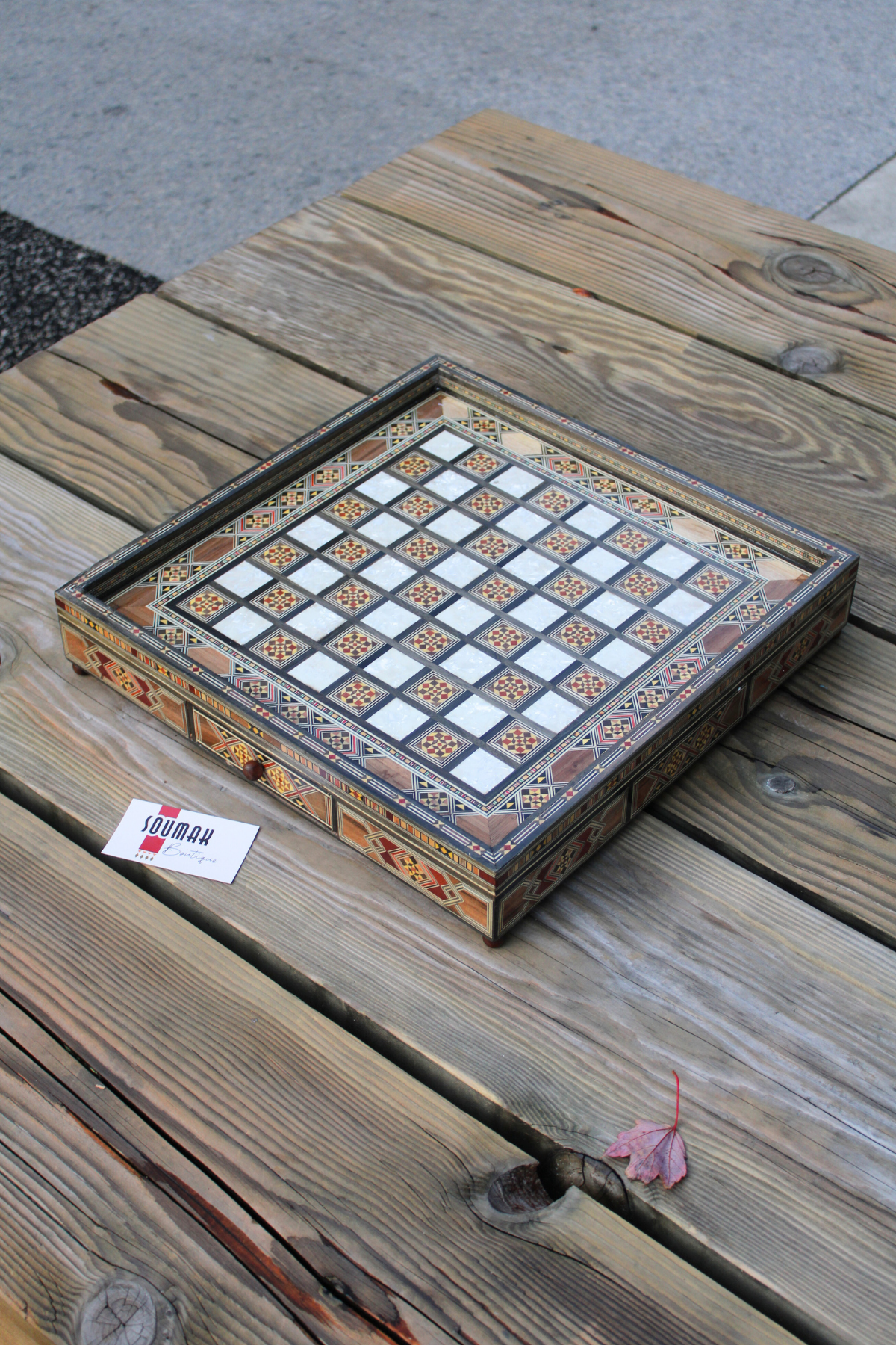 Wider side view of the handcrafted chess board with the drawer closed, capturing the elegant design and beautiful pattern while showcasing the rich wood finish and overall craftsmanship of the set.