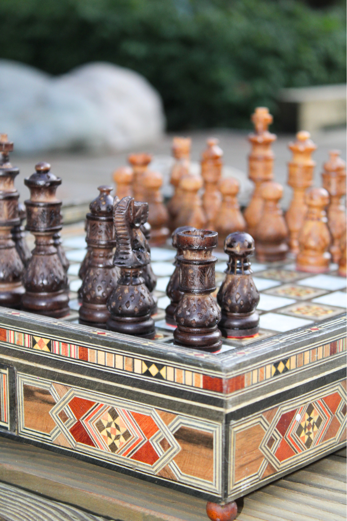 Close-up view of the resin chess pieces, highlighting their intricate designs and vibrant colors against the polished wood surface of the chess board, showcasing the craftsmanship and attention to detail.