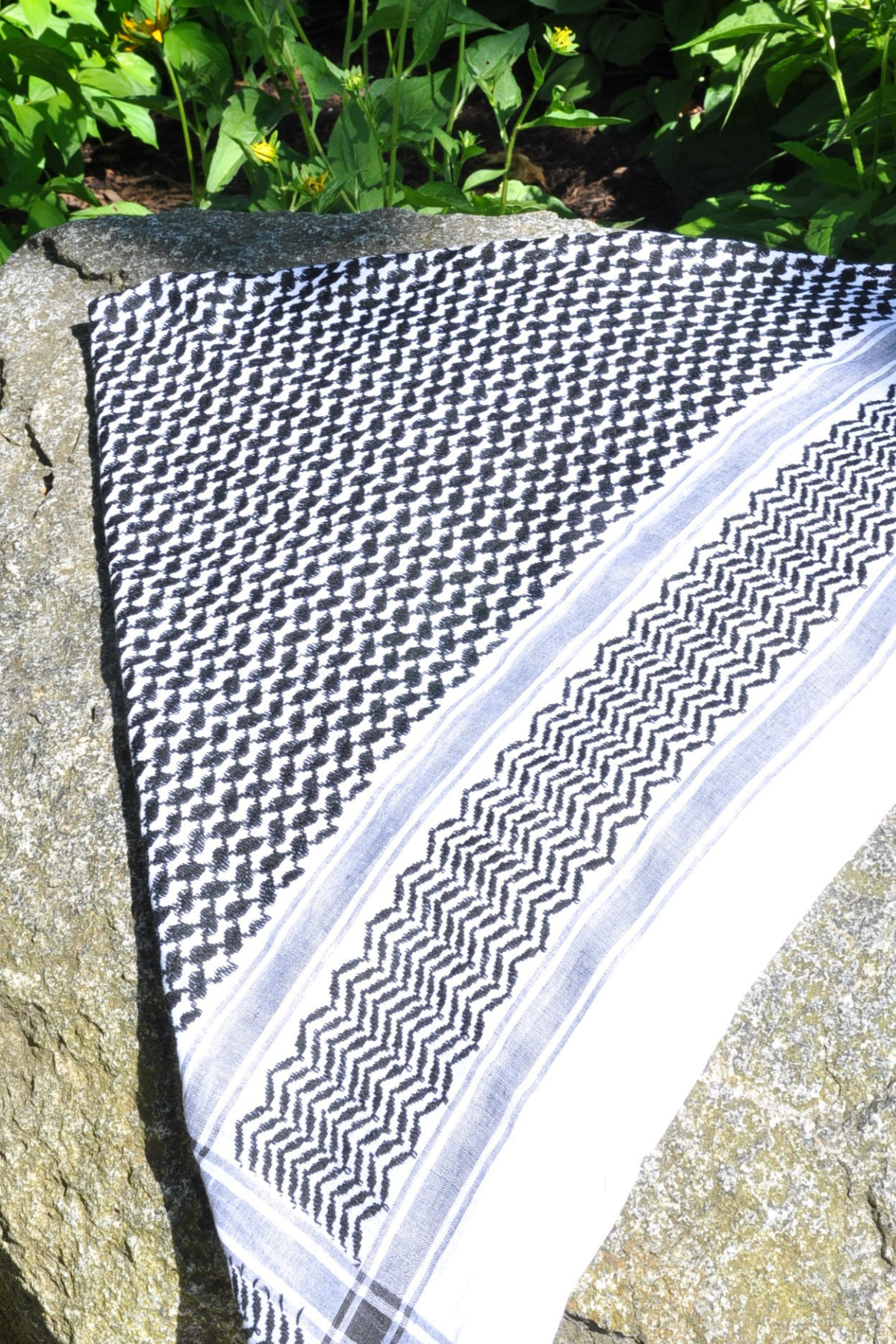 A classic black and white Keffiyeh adorned with tassels. This handwoven scarf is a symbol of resilience and heritage, perfect for everyday wear or special occasions.