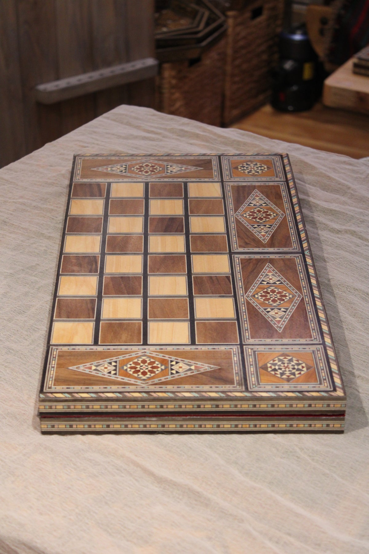 Chess board foldable on a table showing the mosaic wood and mother of pearl, it folds and it is handy