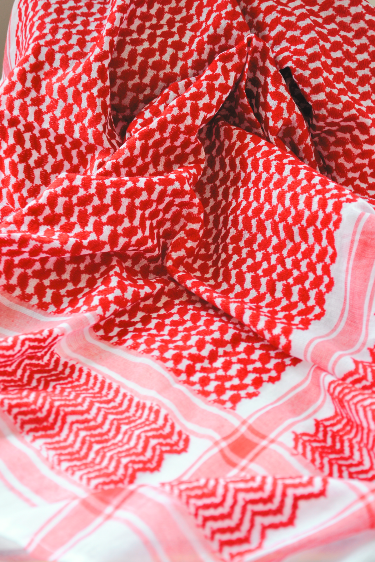 A clean, tassel-free red and white Keffiyeh scarf, made on a semi-machine loom with precision. This iconic accessory reflects cultural pride while offering a minimalist design.