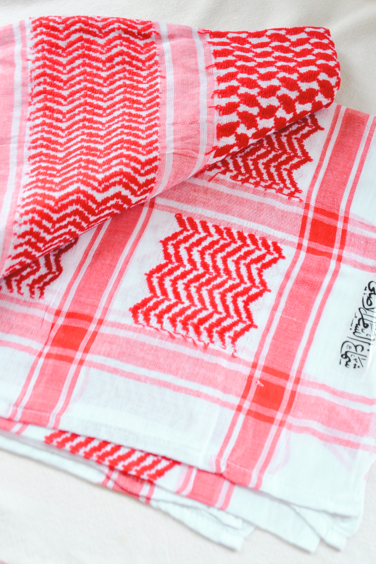 Traditional red and white Kufiya scarf, crafted without tassels for a sleek and modern look. Made on a semi-machine loom, perfect for honoring cultural heritage with a contemporary twist.