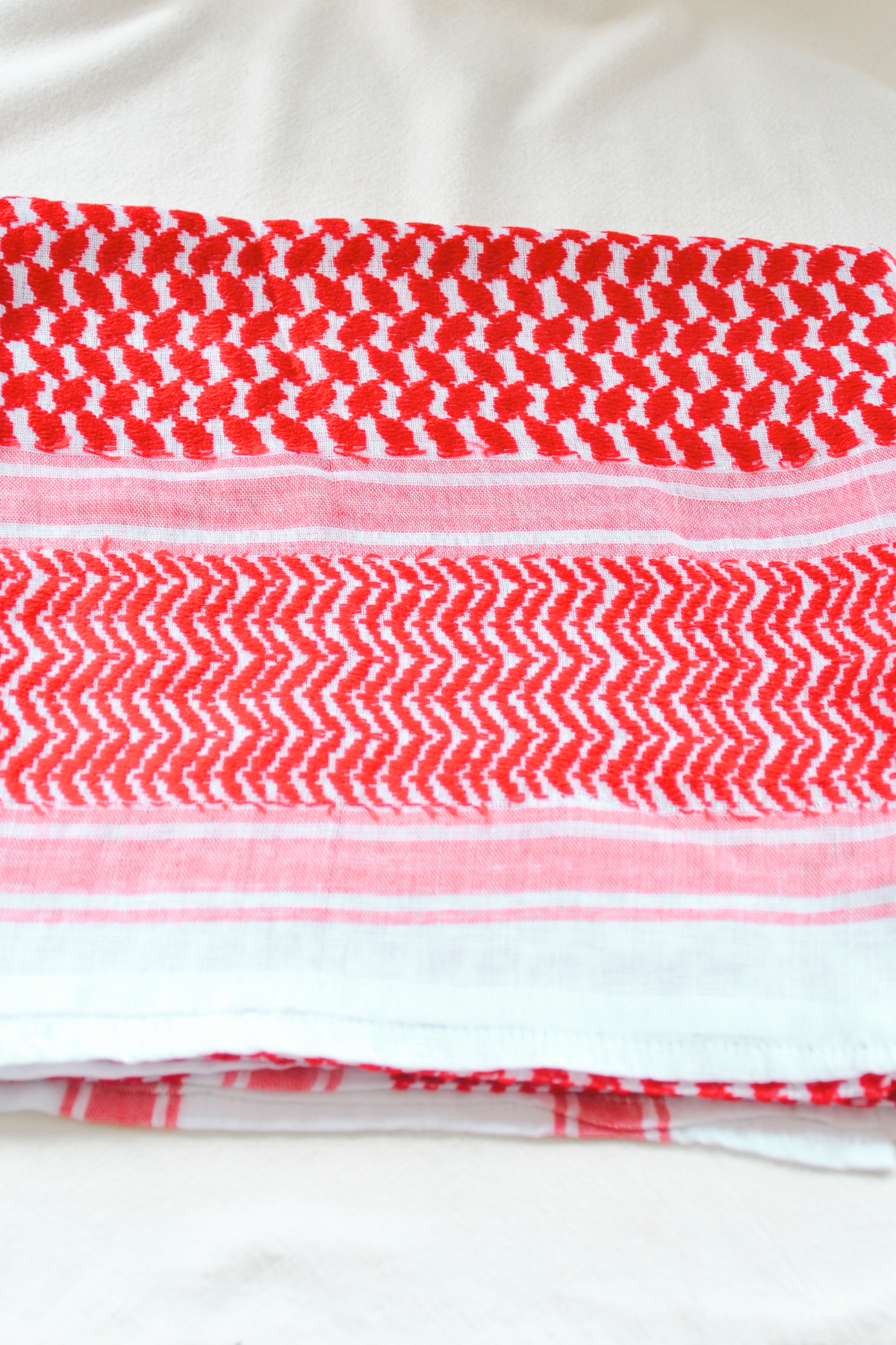  Iconic red and white Shemagh scarf, made without tassels for a minimalist style. Handmade to reflect Middle Eastern tradition in a fresh, modern design.