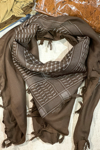 Chocolate Kuffiyeh scarf beautifully styled, illustrating its versatility and vibrant patterns for any occasion.