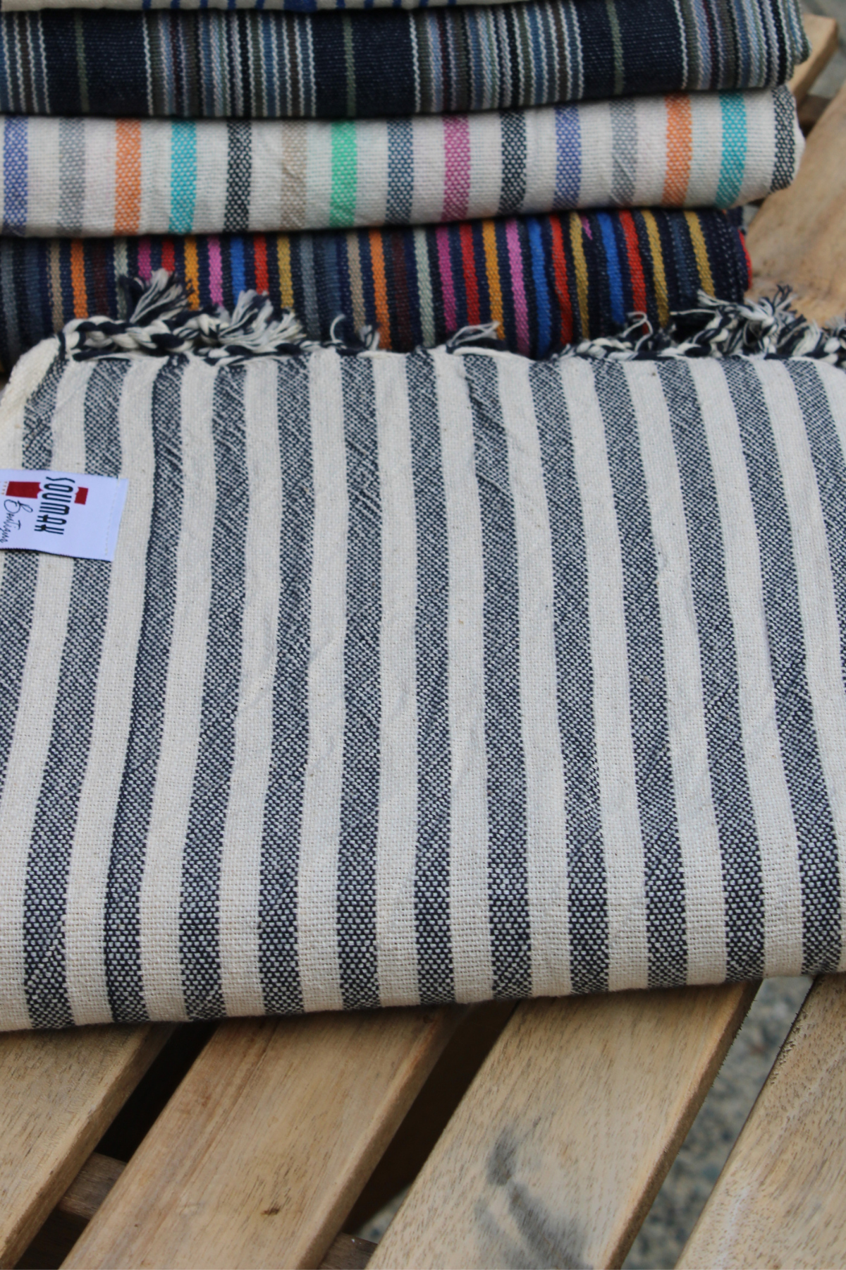 A neatly folded Turkish Hamam Towel in black and white stripes, displayed at Soumak Boutique, Kids Market, Vancouver, BC, Canada.