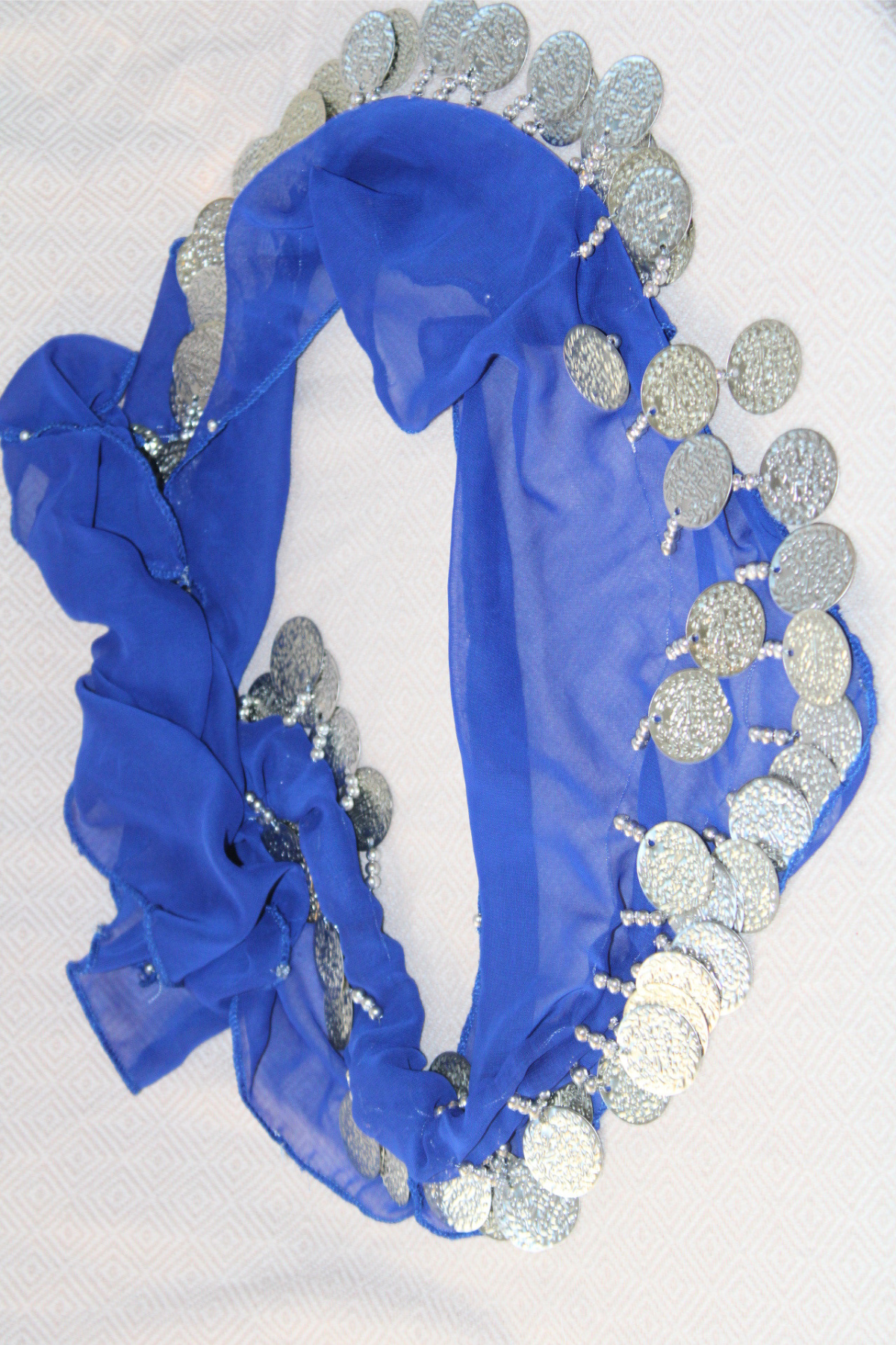 A deep blue belly dance waist chain featuring two layers of silver coins. This bold and vibrant color brings energy and movement to your belly dance routine while the silver coins add shimmering flair.
