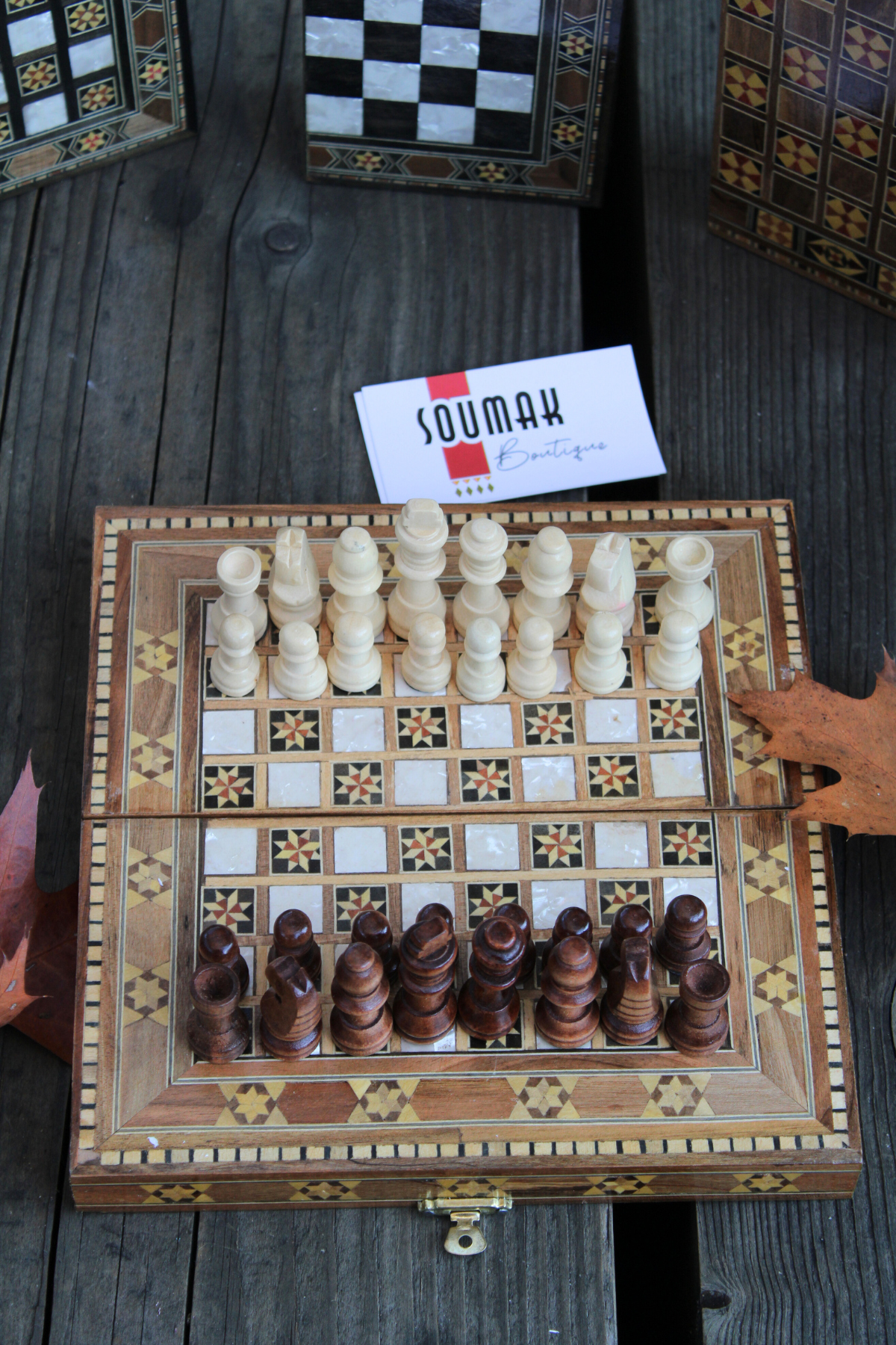 Chess side of the Mini Syrian Board adorned with intricately carved chess pieces, showcasing its unique star geometric design.