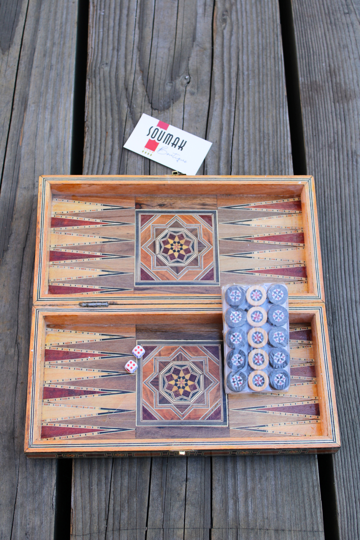 View of the backgammon side of the Classic Elegance Chess and Backgammon Board, adorned with wooden backgammon pieces and dice. The classic black and white design adds a touch of sophistication to your game night, inviting fun and camaraderie.