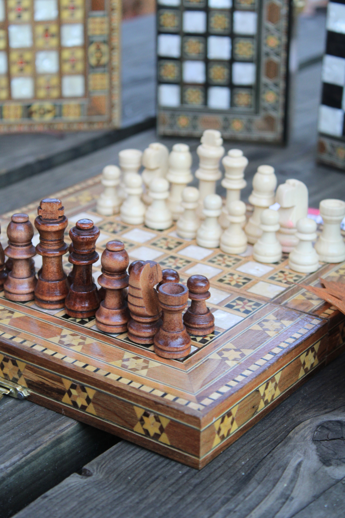 Close-up view of the intricately carved wooden chess pieces on the Mini Syrian Board, highlighting the craftsmanship and star motif design.

