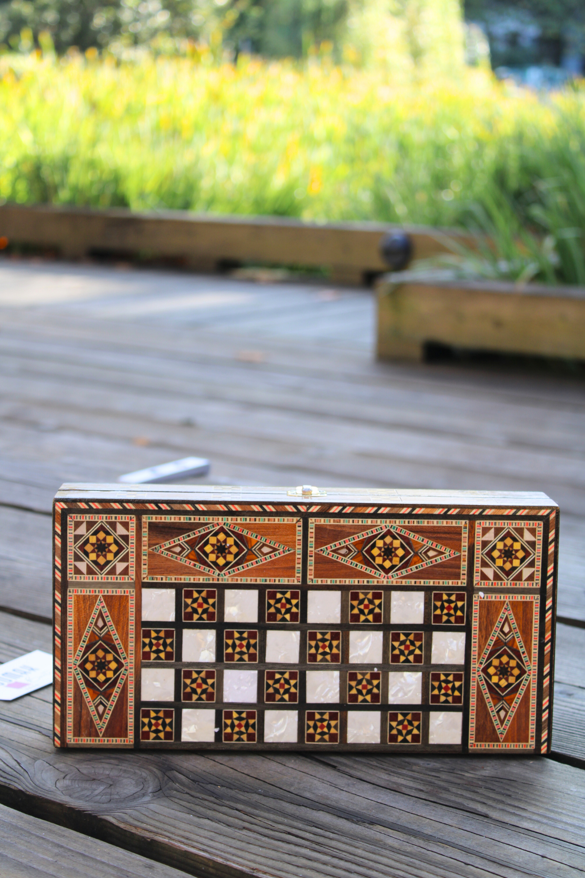 Horizontally closed view of the Golden Blossom Mosaic Chess and Backgammon Board, showcasing its exquisite floral mosaic and smooth finish. This captivating board brings a touch of luxury and artistry to any room, making it a delightful addition to your home.

