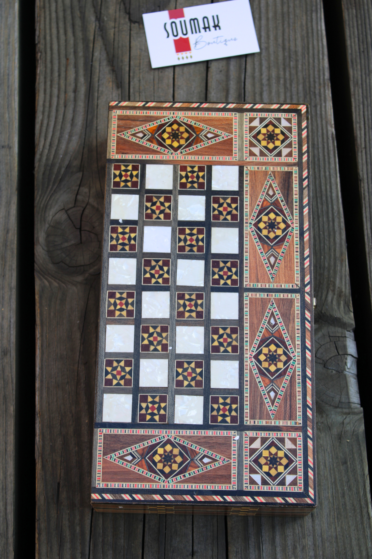 Closed view of the Golden Blossom Mosaic Chess and Backgammon Board elegantly laid down, showcasing its vibrant yellow floral design intertwined with intricate mosaic patterns and mother of pearl inlay. This beautifully crafted board adds a touch of elegance to any space, perfect for display or gifting. Available at Soumak Boutique.