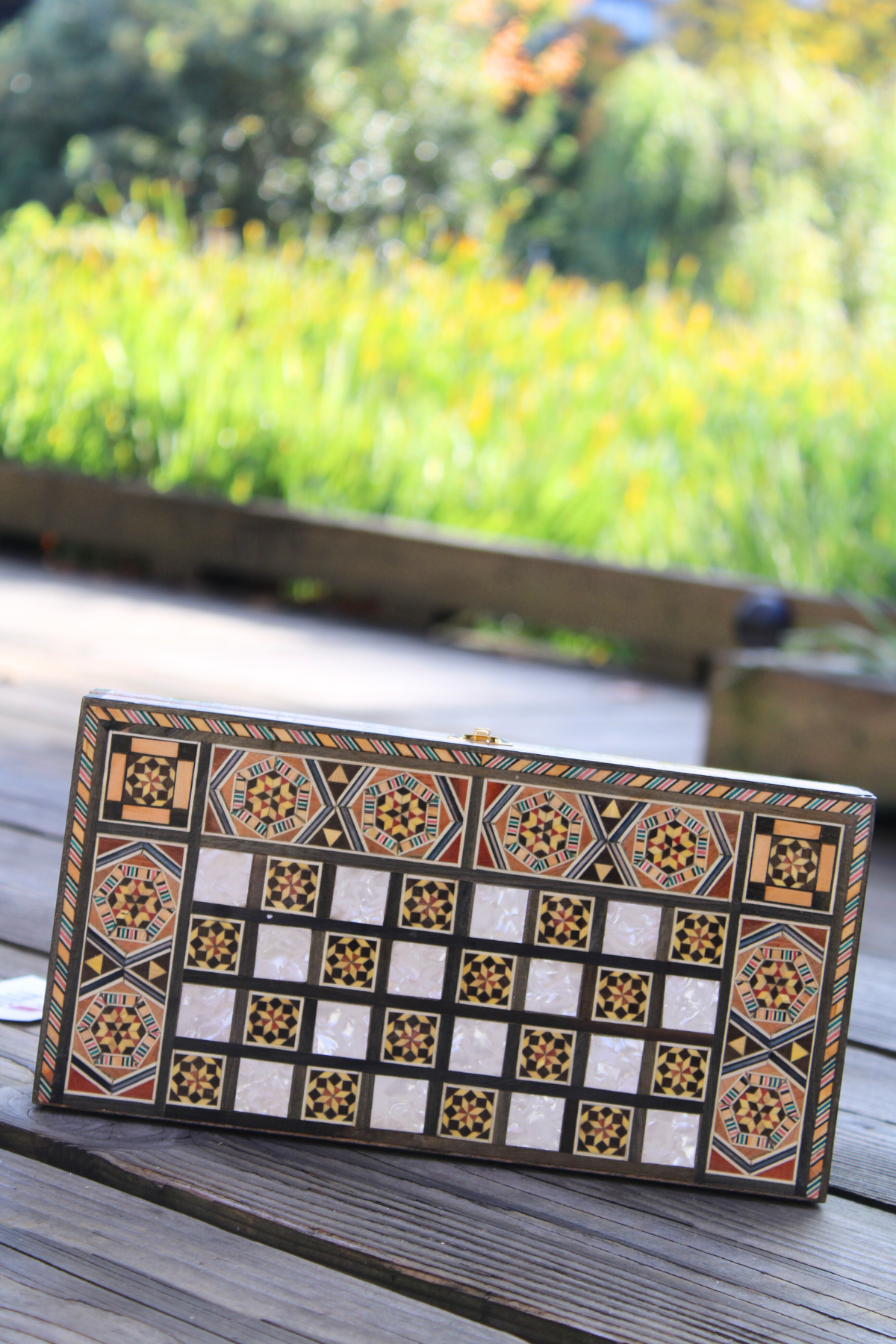 Horizontally closed view of the Sunlit Blossom Mosaic Chess and Backgammon Board, showcasing its vibrant floral design and smooth finish. This enchanting piece enhances any room's decor, making it a perfect addition to your home.