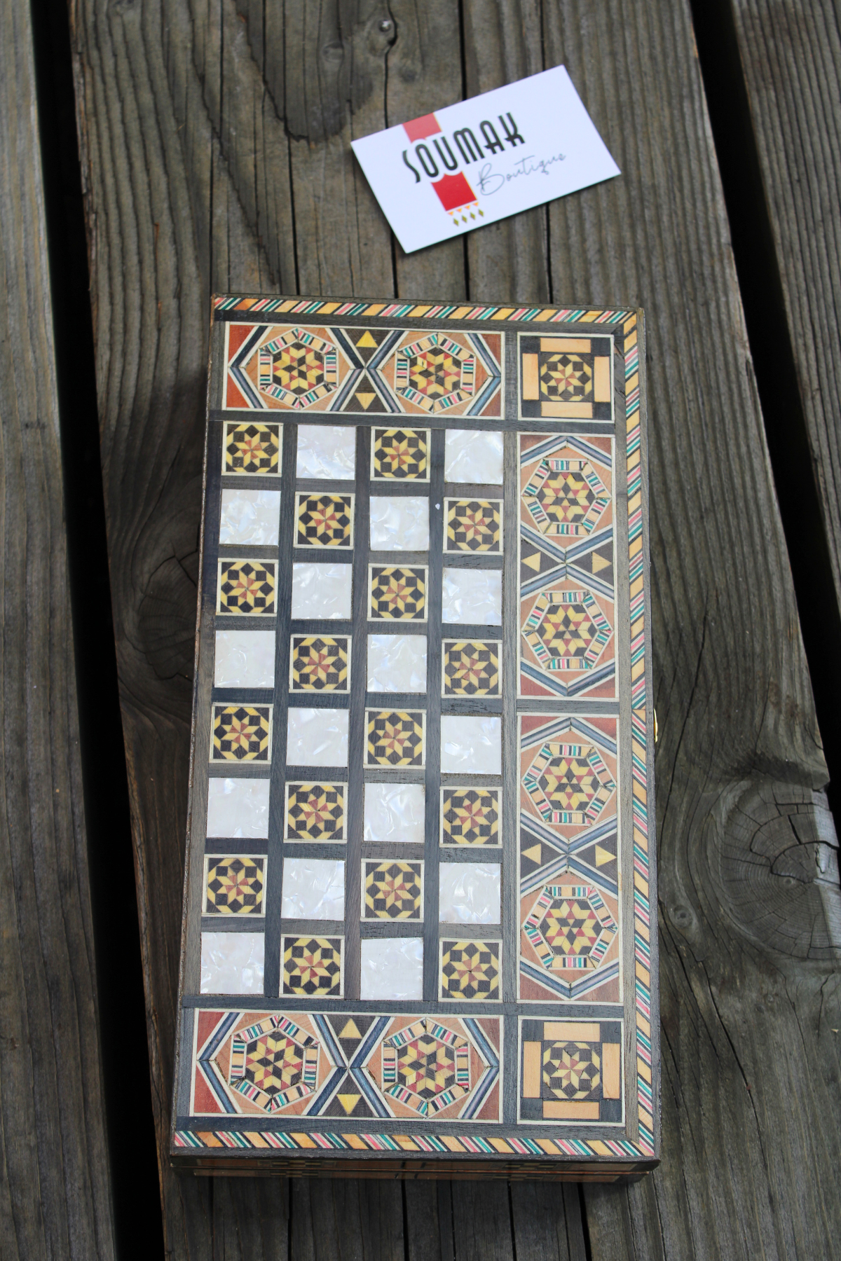 Closed view of the Sunlit Blossom Mosaic Chess and Backgammon Board elegantly laid down, emphasizing its stunning floral mosaic design. This beautifully crafted board adds a touch of artistic elegance to any space, perfect for display or gifting. Available at Soumak Boutique.



