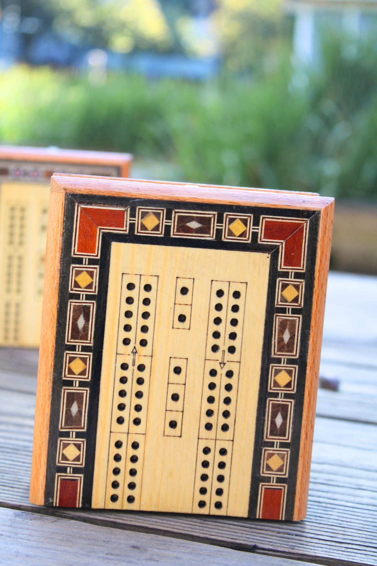 Side view of the folded handcrafted Syrian mosaic mini cribbage board standing on its left side, highlighting its compact design and intricate mosaic patterns. This elegant piece is perfect for travel and stylish storage, available at Soumak Boutique.