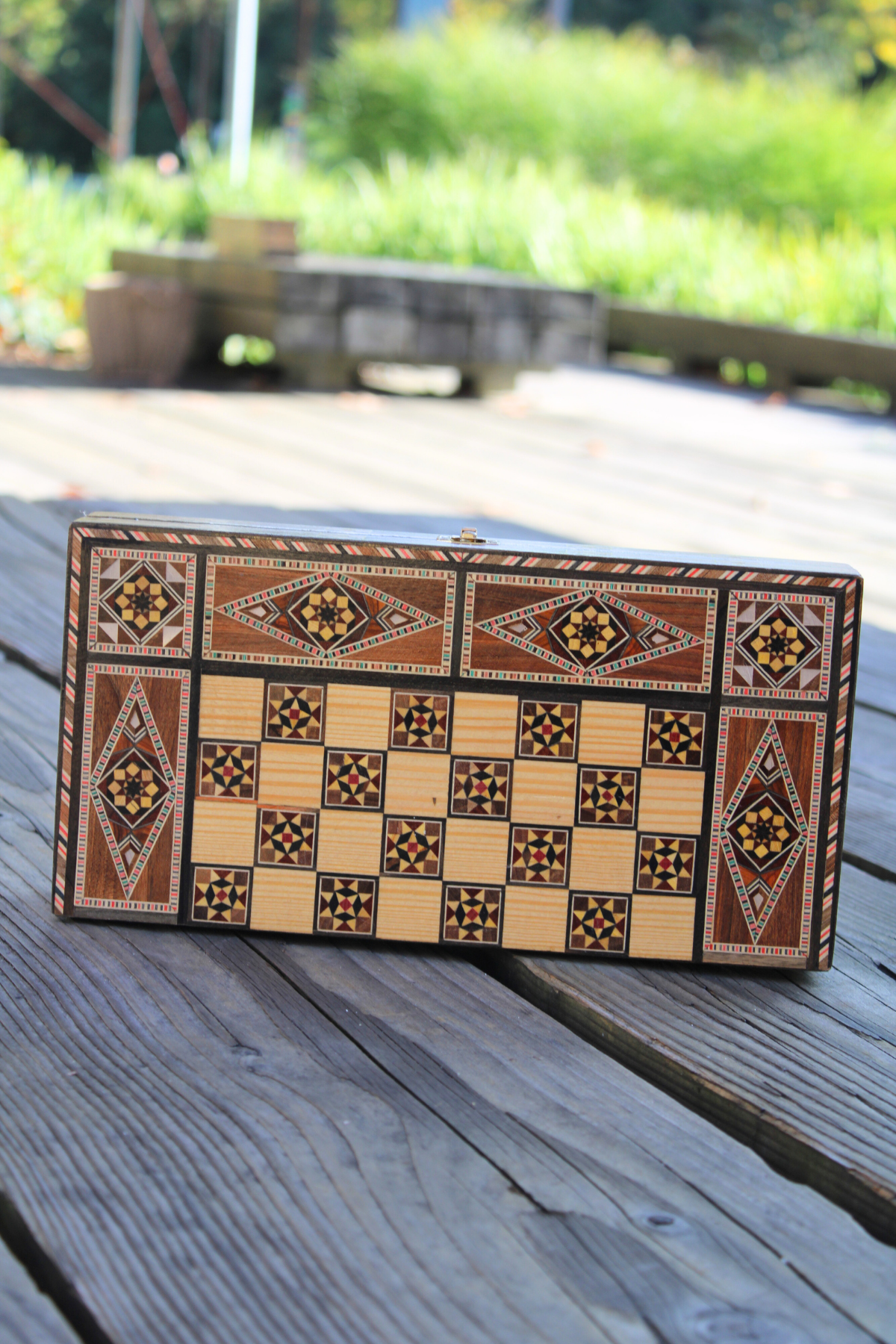 Horizontally closed view of the Woodland Mosaic Chess and Backgammon Board, highlighting its beautiful wooden mosaic craftsmanship. This elegant board seamlessly blends art and function, making it a captivating addition to your decor.