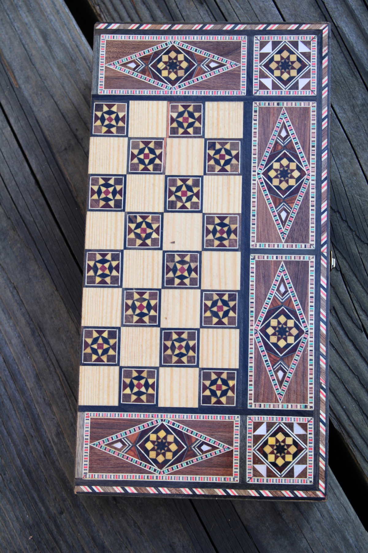 Laid-down view of the closed Woodland Mosaic Chess and Backgammon Board, showcasing its rich wooden mosaic patterns. This elegant piece serves as both a game and a striking decorative item, adding warmth and sophistication to any setting.